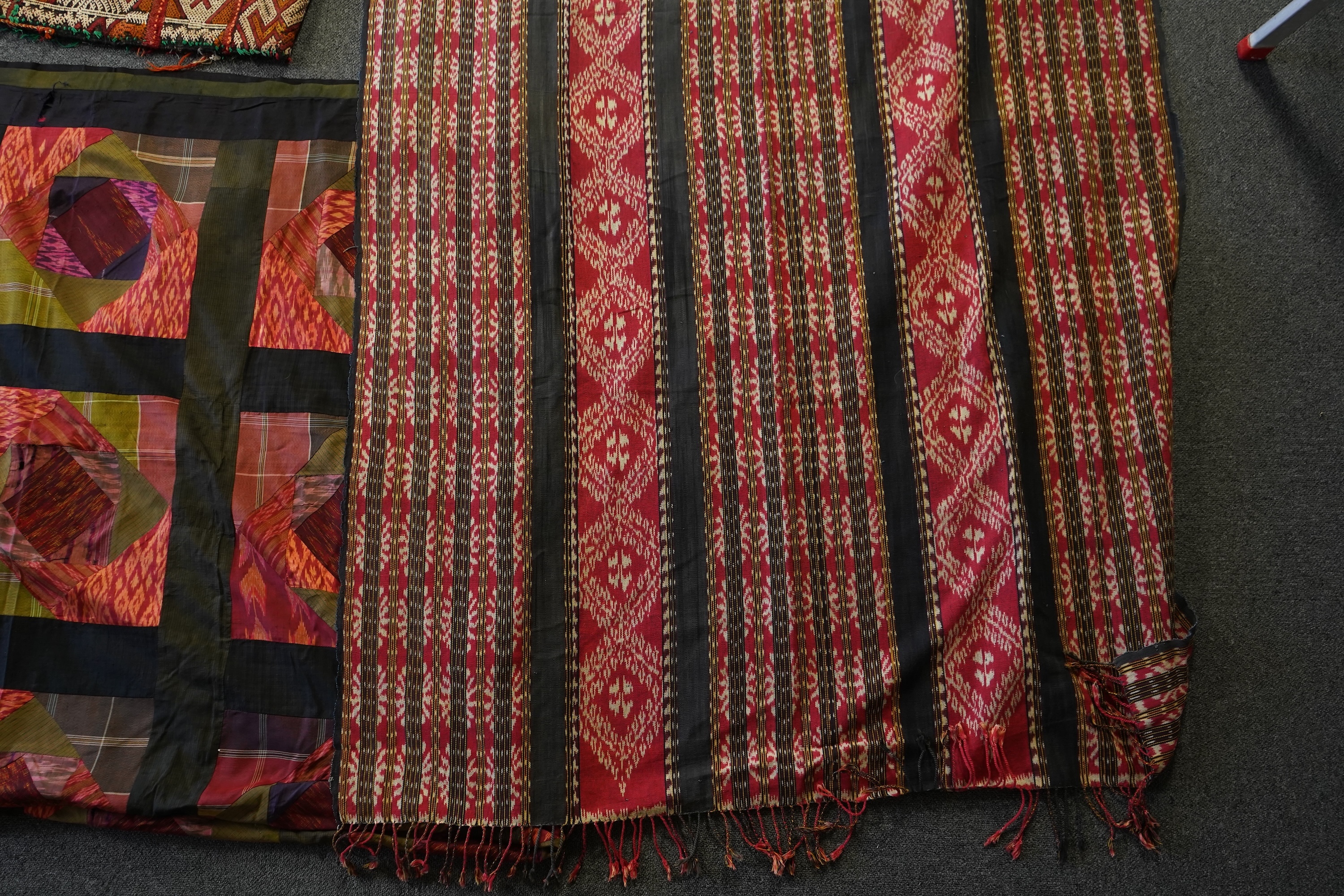 A 20th century Indonesian Sumba single Ikat shoulder cloth, a similar Celebes cloth, a Berber woven skirt and saddle bag and a patchwork cover. (5). Skirt 110cm including hessian top., Condition - some patchwork in the c
